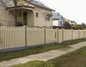 Cream steel picket fence with grey posts and bottom rail