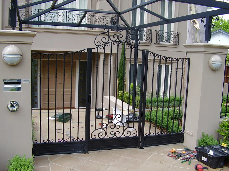 Black wrought iron fence and swing gate
